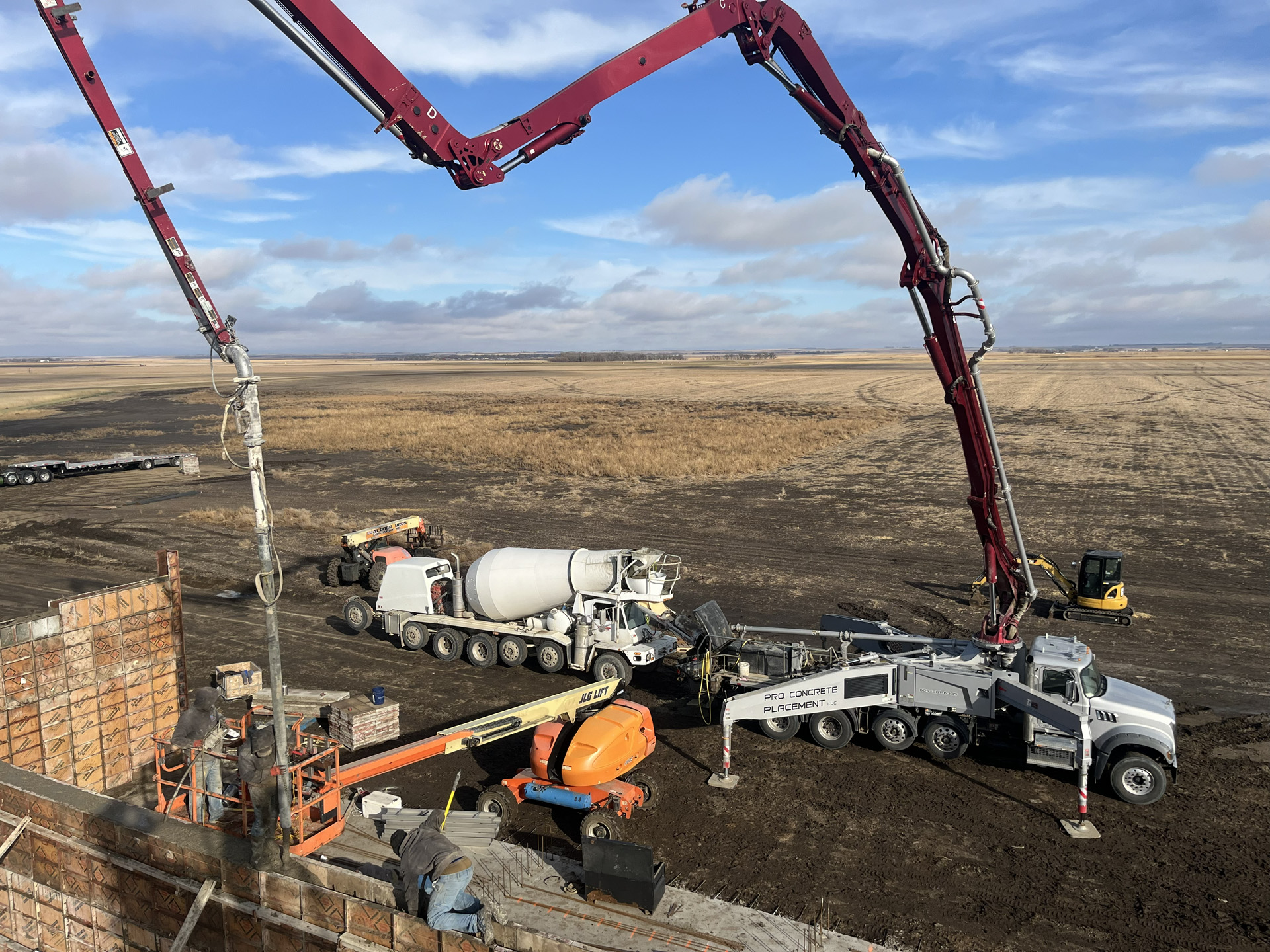 Boom pump placing concrete for an agricultural wall project