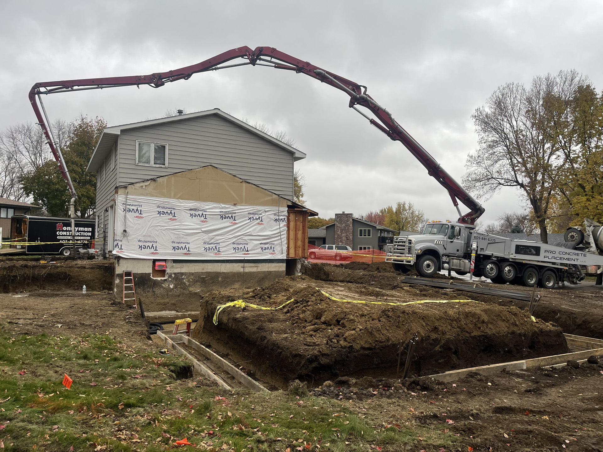 Concrete boom pump extended over a residential foundation project