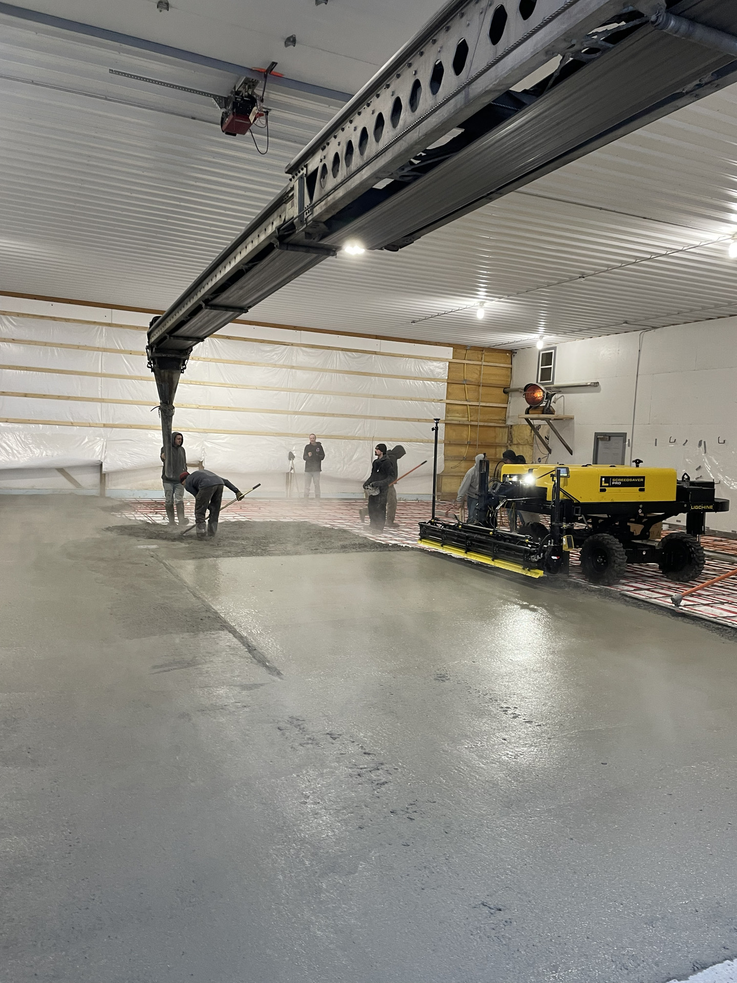 Telebelt assisting with an interior concrete floor pour
