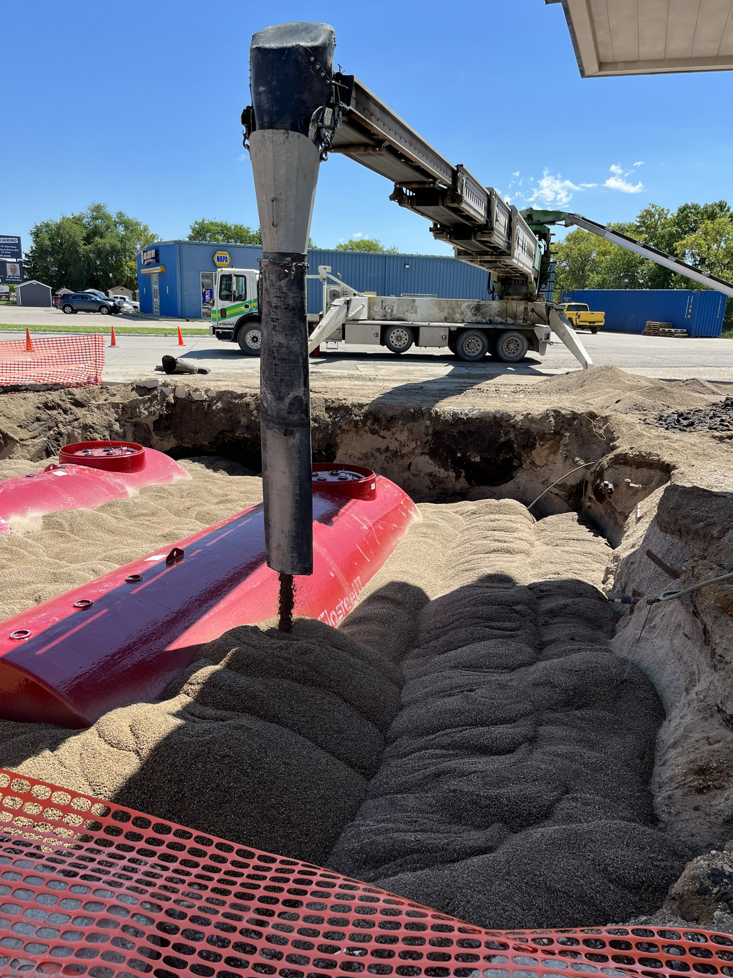 Telebelt placing aggregate around buried tanks